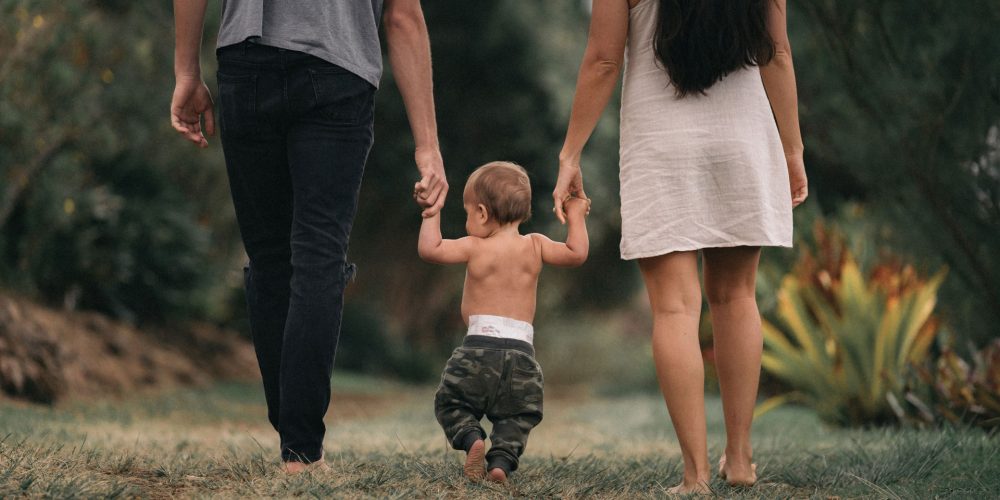 baby-walking-with-parents